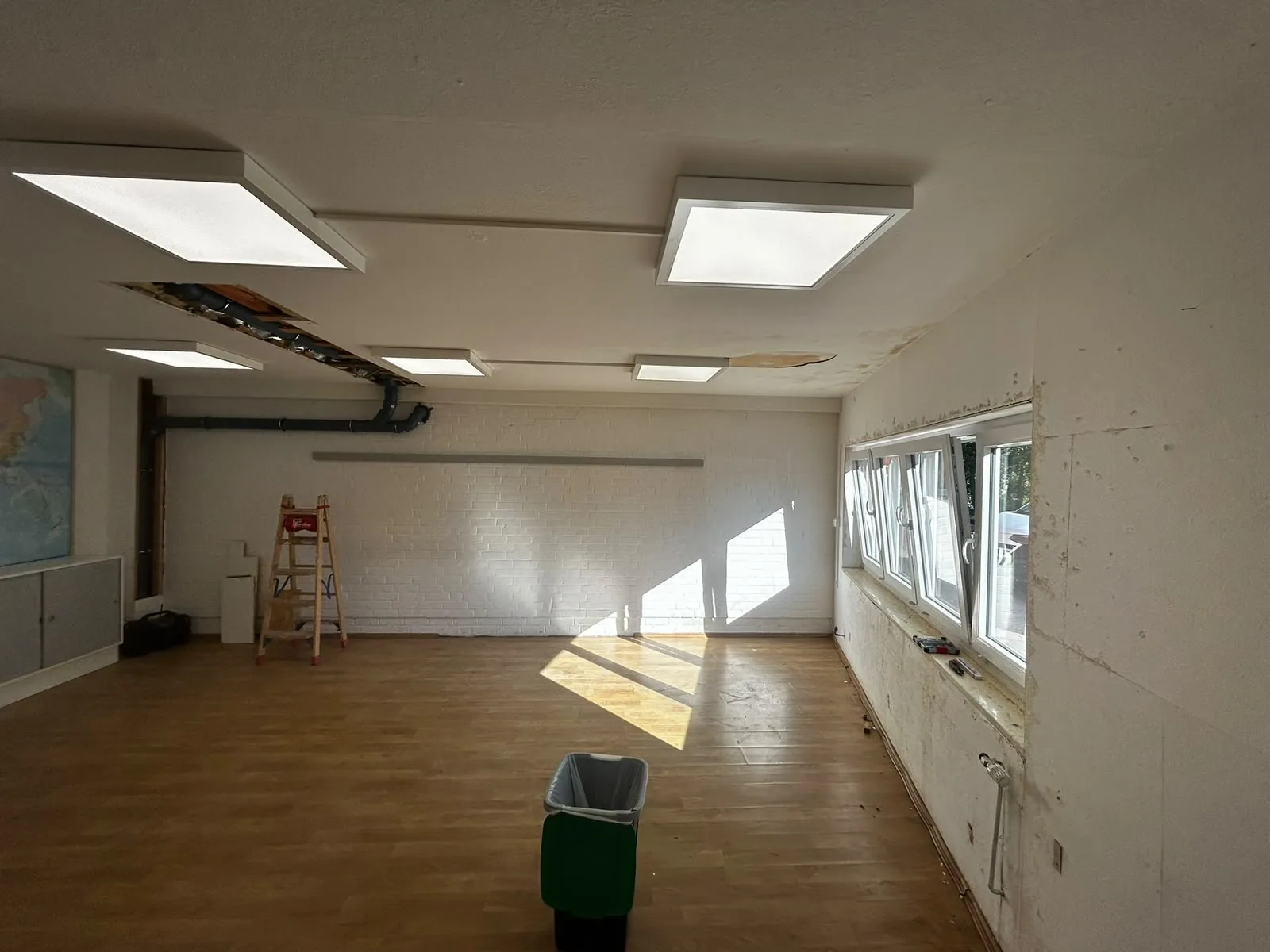 Innenraum vor der Sanierung mit beschädigter Decke und altem Boden